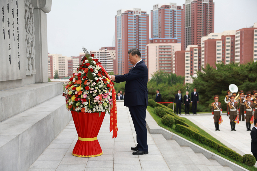 当地时间6月9日上午,正在朝鲜进行国事访问的中共中央总书记、国家主席习近平和夫人彭丽媛参谒中朝友谊塔。朝鲜劳动党总书记、国务委员长金正恩和夫人李雪主陪同。这是习近平整理花篮缎带。新华社记者 丁海涛 摄