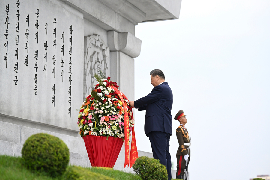 当地时间6月9日上午,正在朝鲜进行国事访问的中共中央总书记、国家主席习近平和夫人彭丽媛参谒中朝友谊塔。朝鲜劳动党总书记、国务委员长金正恩和夫人李雪主陪同。这是习近平整理花篮缎带。新华社记者 谢环驰 摄