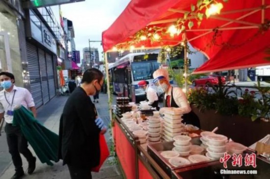 資料圖：當地時間8月16日晚，一家中餐廳在紐約法拉盛社區街道旁外賣菜肴。隨著紐約經濟活動的恢復，當地民眾夜間活動逐漸增多。<a target='_blank'  data-cke-saved-href='http://www.chinanews.com/' href='http://www.chinanews.com/'><p  align=