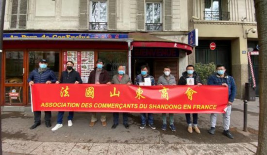 法國山東商會在巴黎老山東餐館前為鄉親們發放香囊。