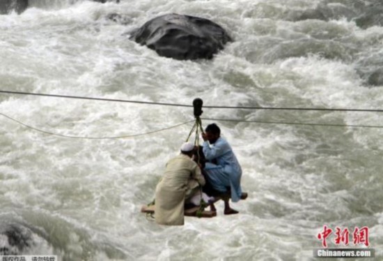 图为巴基斯坦洪灾导致桥梁损毁 民众使用各种方法渡河