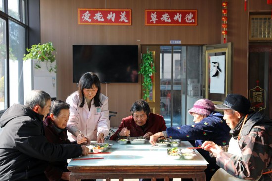 2025年12月28日，護理人員在江蘇省海安高新區隆政街道德興村親上親養老小院照顧老人用餐。新華社發（顧彬斌 攝）