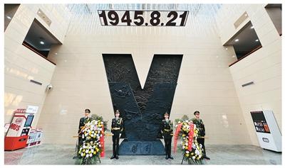 图为与会人员向中国人民抗战胜利受降纪念馆内的胜利V字雕塑献花。卢嘉俊摄